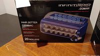 Two boxed Conair Infiniti Premier ceramic hair setter units each with 20 ceramic rollers inside, detailed product image showing the rollers and box design.