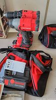 Two Craftsman cordless drills stacked with two rechargeable batteries and a Craftsman charger in front on a surface next to a soft case.