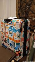 Front and side view showing colorful Canadian themed hardcase luggage with wheels and black zipper