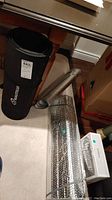 Photo showing Manduka yoga mat in black carrying bag beside the windshield sun shields rolled up.