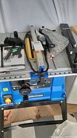 Front view of Mastercraft table saw on steel stand with accessories.