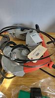 Overall photo of Milwaukee scroll saw showing body and cord with blades.
