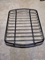 Top view of black metal roof basket with rectangular shape and horizontal bars.