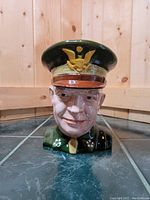 Front view of ceramic character mug depicting General Eisenhower's bust in his green military uniform and hat with gold eagle emblem.