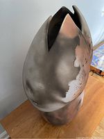 Side view of erotic Raku ceramic sculpture showing abstract petal-like forms and earthy smoke patterns