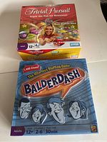 Photo showing two board games: Trivial Pursuit and Balderdash stacked with visible front covers.