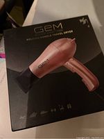 Front of the GEM Mini Folding Handle Travel Dryer box showing image of the rose gold colored dryer and brand/logo details.