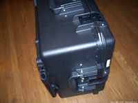 Side view of black Pelican Storm IM2750 hard case with focus on latches and wheels