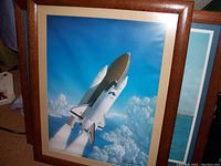 Full view of framed print depicting Space Shuttle Columbia ascending above clouds.