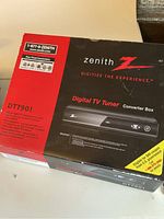 Original Zenith DTT901 digital TV tuner converter box in red and black packaging showing branding and model info.