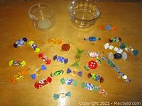 Overall view of glass candy figurines arranged on a wooden surface with two clear glass dishes.