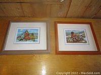 Two framed art prints by Nori Peters placed side by side on a wooden surface.