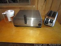 Photo showing the oven, toaster, and Brita pitcher side by side on a wooden countertop under a window.
