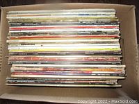 Box filled with over 50 vinyl records packed side-by-side showing album spines