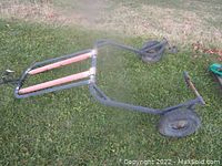 Metal snowmobile dolly on grass, showing the structure and condition