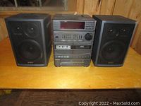 Full stereo system with main unit and two black Sony speakers on wood surface.