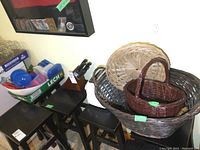 Photo of multiple wicker baskets, black wooden stools, and plastic storage containers. Also visible is the Henckels carving knife block in the background.