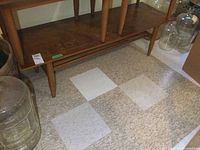 Front and side view of vintage wooden coffee table showing tapered legs and lower shelf. Visible surface wear and watermarks.