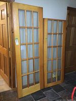 Photo showing both French doors standing upright, highlighting the wood finish and glass panes layout.