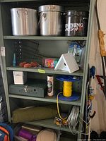 Closer view of middle shelf with pots, showing labels and condition