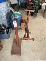Full view of wooden wool winder showing base, vertical support, horizontal winding bar with handle.
