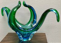 Front angle view showing the bowl's flowing curved arms and color gradient from green to blue.