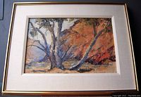 Frontal view of the framed impressionist oil painting showing the landscape with trees and orange foliage in the background.