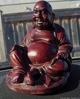 Front perspective of the carved rosewood Buddha with detailed facial features, sitting cross-legged.