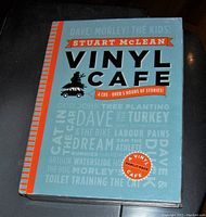 Front cover of boxed set featuring the title 'Vinyl Cafe' by Stuart McLean with design elements and text.