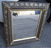 Front view of the Victorian carved wood wall mirror showing detailed leaf and acorn carvings on the frame and gilded inner trim.