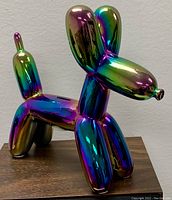 Front left angle view of the iridescent balloon dog bank showing color variation and surface gloss.