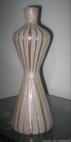 Full front view of vase showing its hourglass silhouette and alternating white and gold latticino stripes