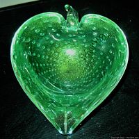 Top-down view of emerald green leaf-shaped bubble glass bowl showing bubble texture and gold infusion inside the glass, with leaf tip detail.