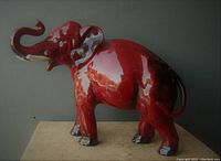 Side view showing vibrant red flambe glaze and raised trunk