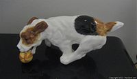 Side view of the Royal Doulton Jack Russell Terrier figurine on a black surface showing the dog holding a ball.