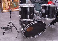 Front angle view of black Westbury bass drum with two mounted tom drums and high-hat stand without feet.
