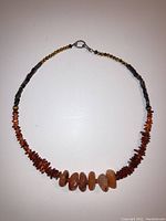 Full view of the multi-stone bead necklace showing amber chip beads, tigers eye beads, agate stones, and clasp.
