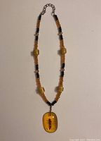 Full view of beaded necklace with amber insect pendant