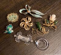 Top view of all 8 vintage brooches showing variety of materials and styles