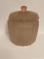 Full view of pink depression glass cookie jar with octagonal lid showing floral motifs and hand painted accents.