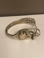 Front angled view of silver plated fork bracelet showing agate gemstone cabochon and ornate handle detailing.