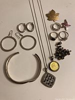 Photo of all jewelry items together on white background showing rings, necklaces, earrings, bangle, starfish motifs, and colorful pendant.