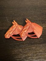 Front view of vintage horse head pin showing detailed carving and reddish-brown Bakelite material.