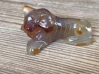 Front angle view of agate lion figurine showing its polished brown and translucent stone surface with carved facial and paw details.