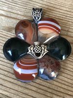 Front view of the Scottish silver and agate flower pendant with visible agate petal stones and central silver thistle detail.