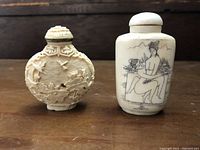 Front view of two snuff bottles showing carved and ink-painted designs