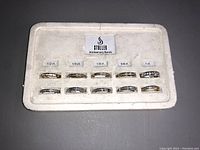 front view of foam display tray with ten anniversary bands labeled by carat weight