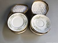 Top view of two stacks of Wedgwood china plates and saucers in padded zippered cases.