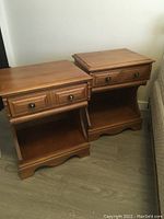 Two matching wooden night tables side by side, showing overall design with drawer and bottom shelf.