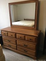 Front view of dresser with mirror placed on top, showing overall condition and style.